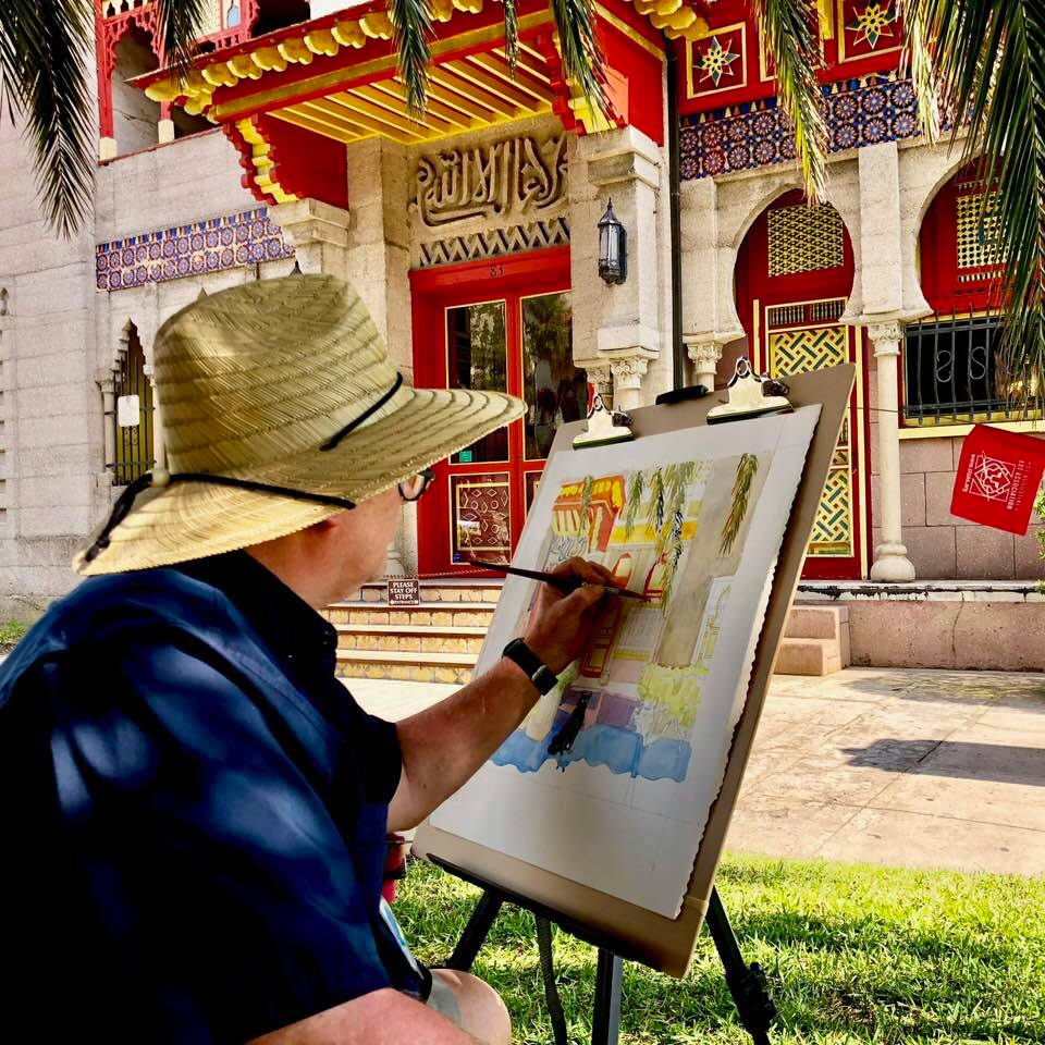 An artist painting the Villa Zorayda Museum outside