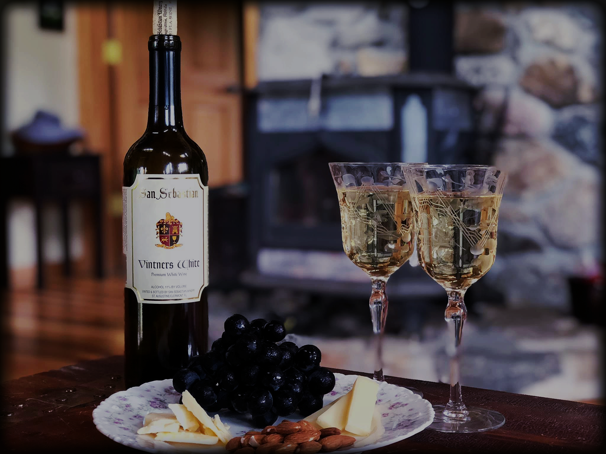 Fruit and cheese plate accompanied with two glasses and a bottle of wine offered at The San Sebastian Winery