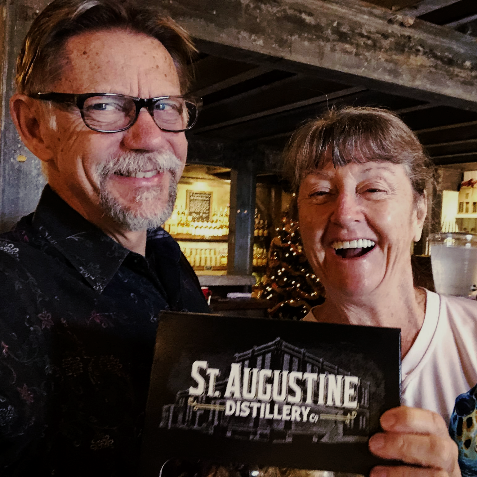 Patrons holding a sign of the St. Augustine Distillery